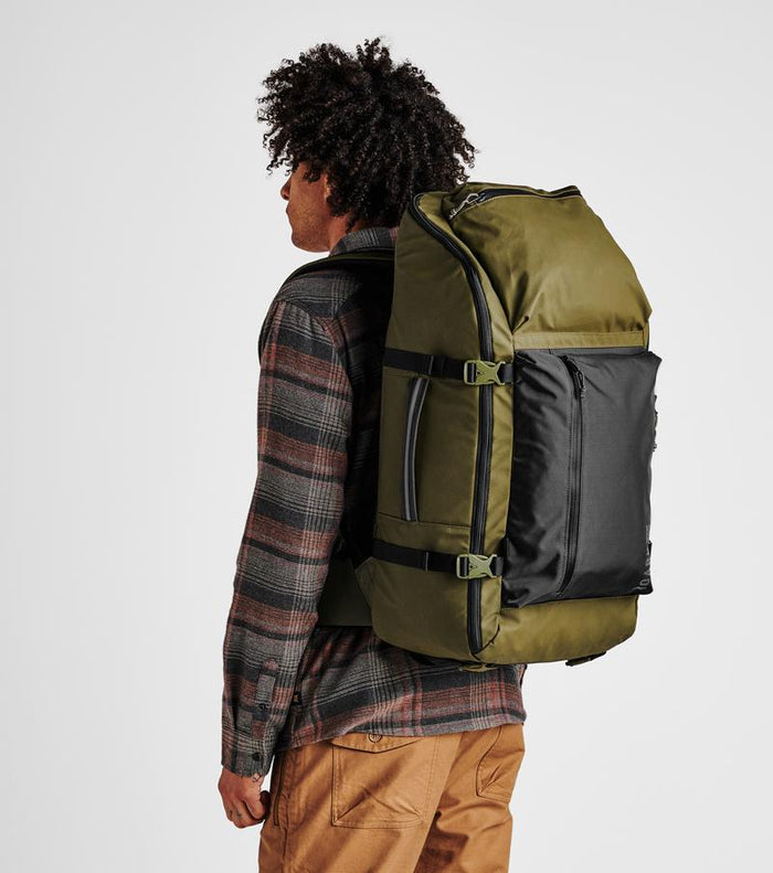 on-model Man wearing the Roark Accomplice Missing Link Bag while commuting through the city, showcasing its sleek design.