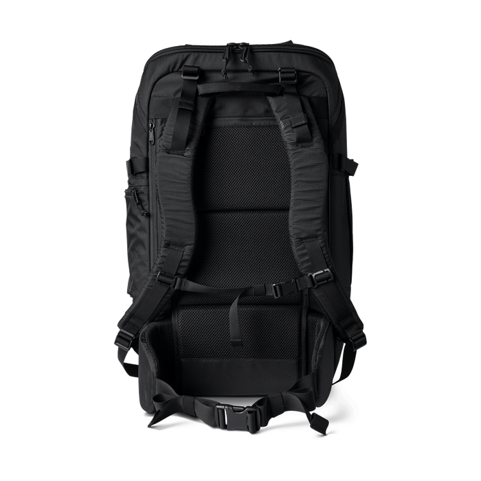 Man carrying the Roark Accomplice Mule 45L duffel bag in black over his shoulder, showcasing its comfortable fit and spacious capacity.