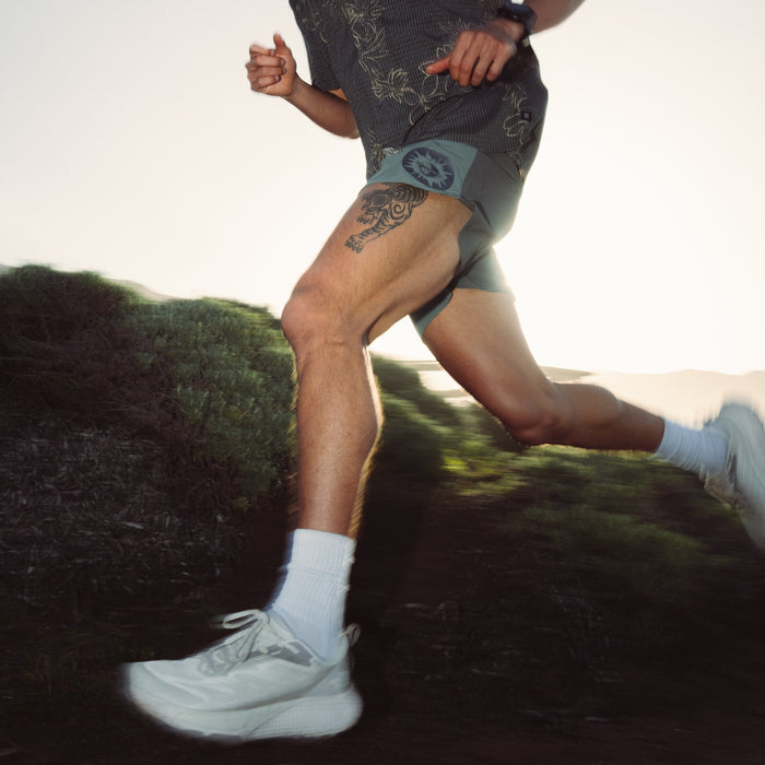 Close-up view of legs wearing Roark Alta 5 Shorts with a focus on adventure-ready design, showing detail from shoes to thighs.