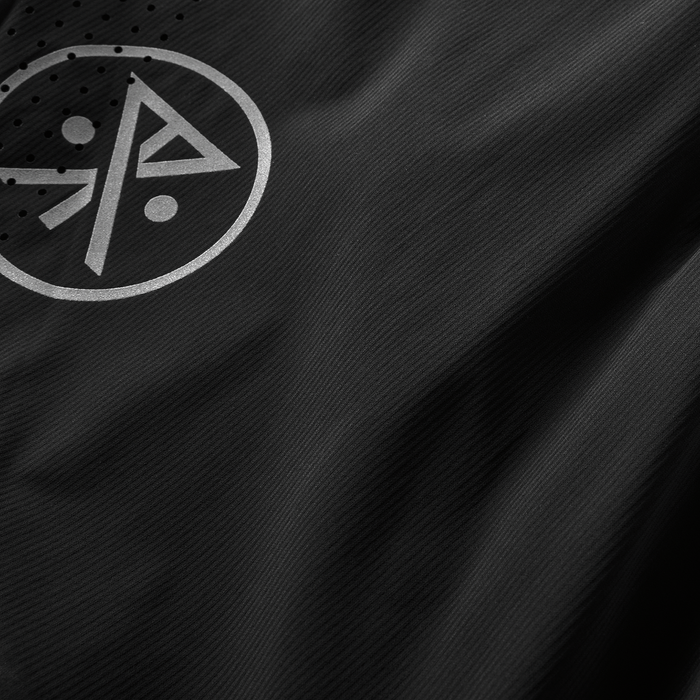 Minimalist logo detail on black fabric shorts with breathable perforated accents for ultimate comfort and style.