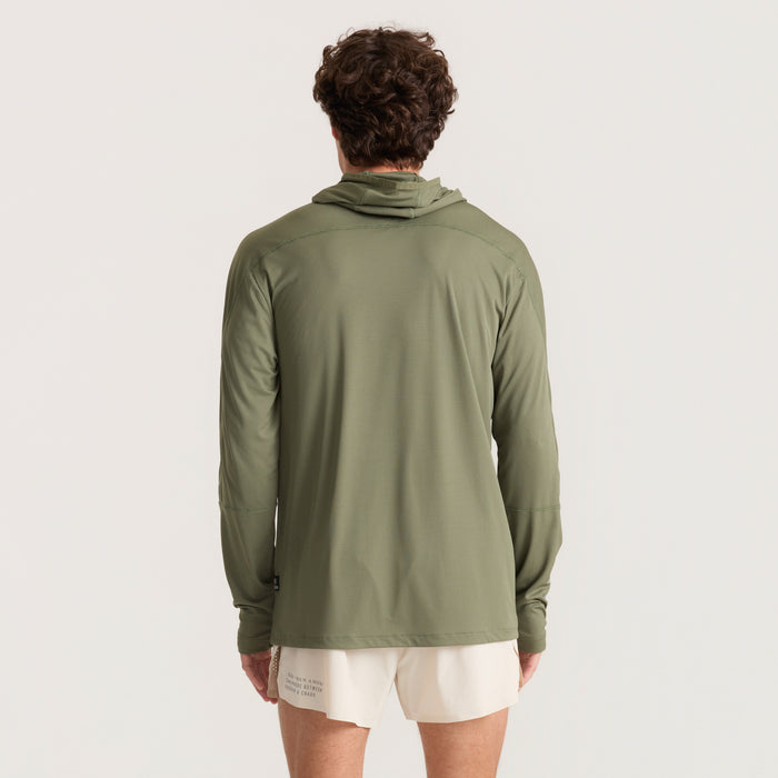 Man wearing a long-sleeved T-shirt with a hood, ideal for adventure and outdoor activities, from Roark's collection.