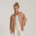 Amberley Light long sleeve flannel in cherrywood plaid worn open over white tee on model with cream pants
