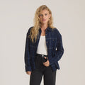 Amberley Light Long Sleeve Flannel in deep navy plaid, worn open over white tank top with black jeans on model
