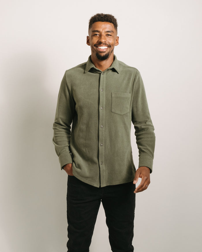 Man wearing a pine green button-up flannel shirt against a plain background
