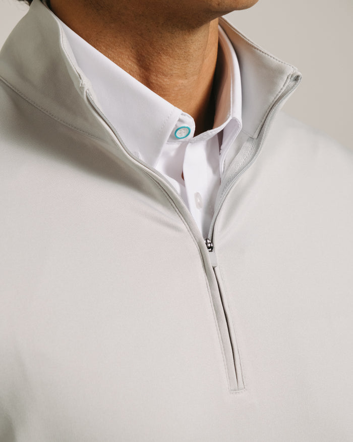 Fog gray gray long sleeve quarter zip over a white shirt with a visible brand logo.