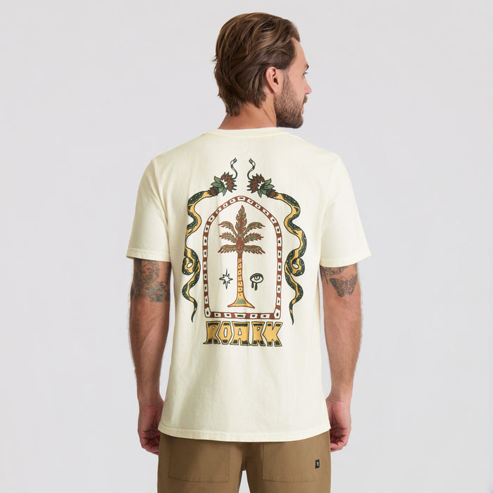 Cream-colored short-sleeve t-shirt with ornate back graphic featuring palm tree, snakes, and mystical symbols in brown and gold tones