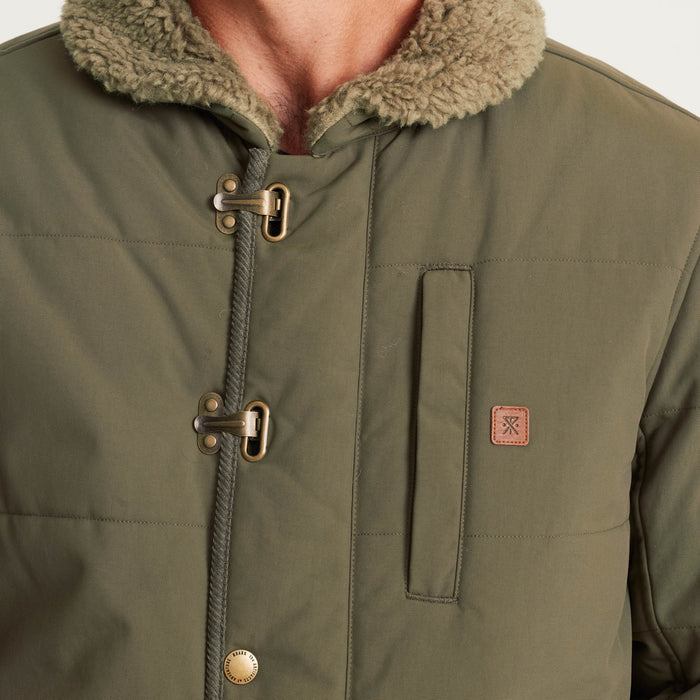 Close-up of a men’s olive green insulated jacket showcasing the toggle closures, sherpa lining, and chest pocket with a branded patch for a classic outdoor aesthetic.