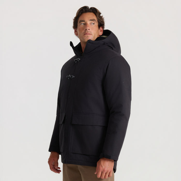 Black Axeman parka jacket with toggle button closures and hood, worn by man against neutral background