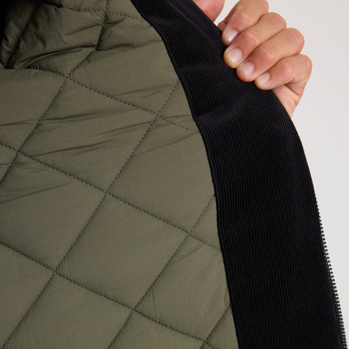 Olive quilted parka jacket with black ribbed knit collar and zipper detail, shown on model from shoulder view