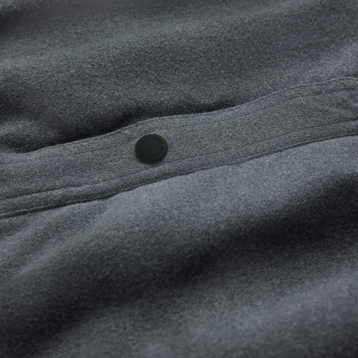 Backwoods Jacket in dark slate gray with black button detail on fabric, close-up flat lay view