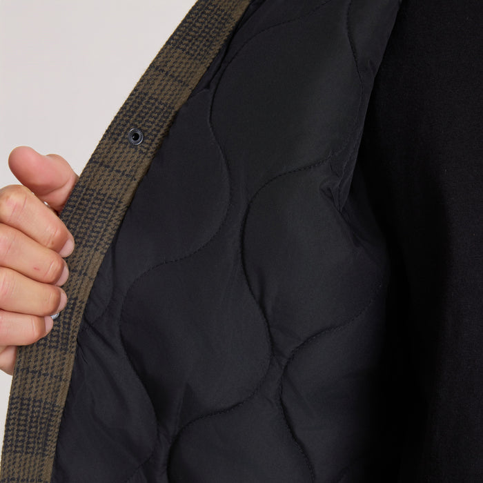 Backwoods Jacket in military green and black worn open, showing quilted black interior and textured outer fabric on model