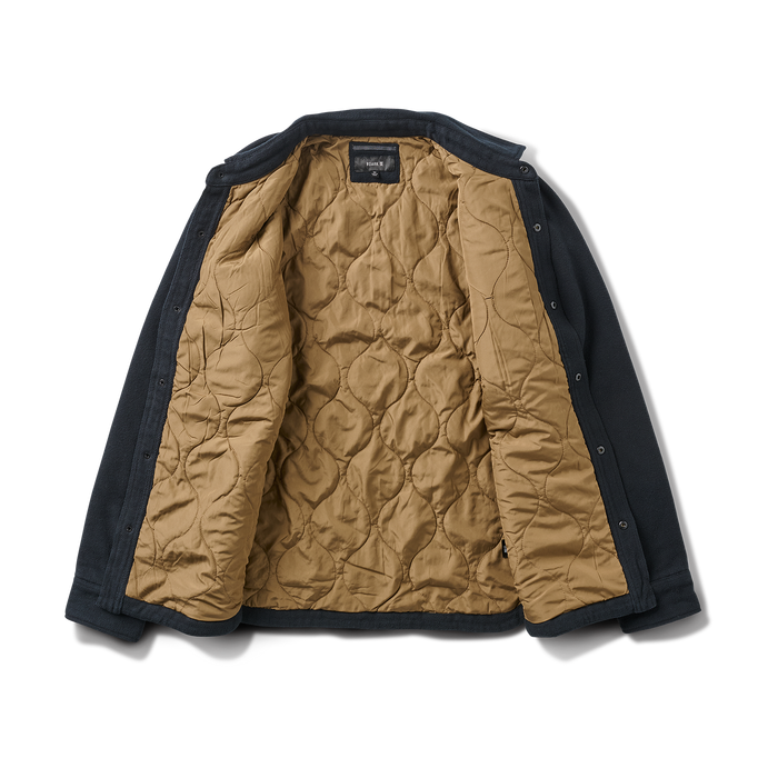 Close-up of a black denim jacket featuring a detailed leather patch, sturdy buttons, and well-crafted pockets, embodying Roark’s commitment to adventure-ready apparel.
