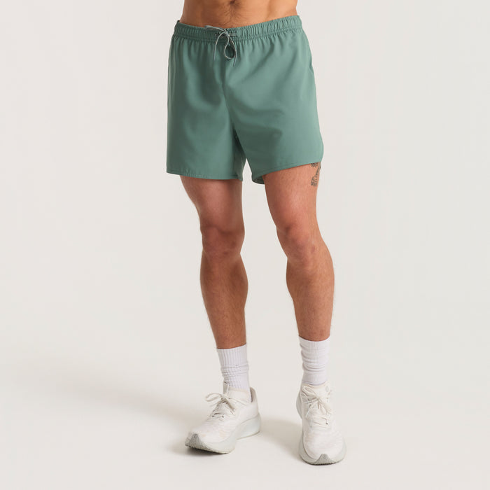Assorted Roark men's shorts including active shorts, boardshorts, trunks, and Bermuda shorts displayed aesthetically, highlighting the calf area for a perfect adventure fit.