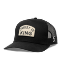 Black cap with 'Christ is King' patch on a white background