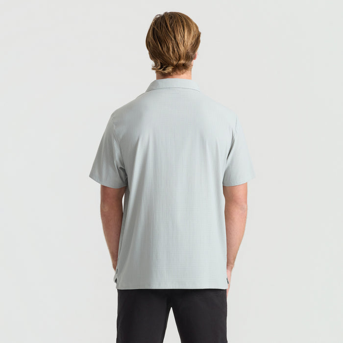 Detail view of a gray Roark active polo shirt featuring a stylish collar, sleeve, and button design, perfect for adventure and travel.
