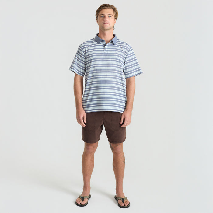 A collection of Roark's adventure-ready gear including a hat, boardshorts, Bermuda shorts, a cap, and a polo shirt, stylishly designed for travel and outdoor activities.