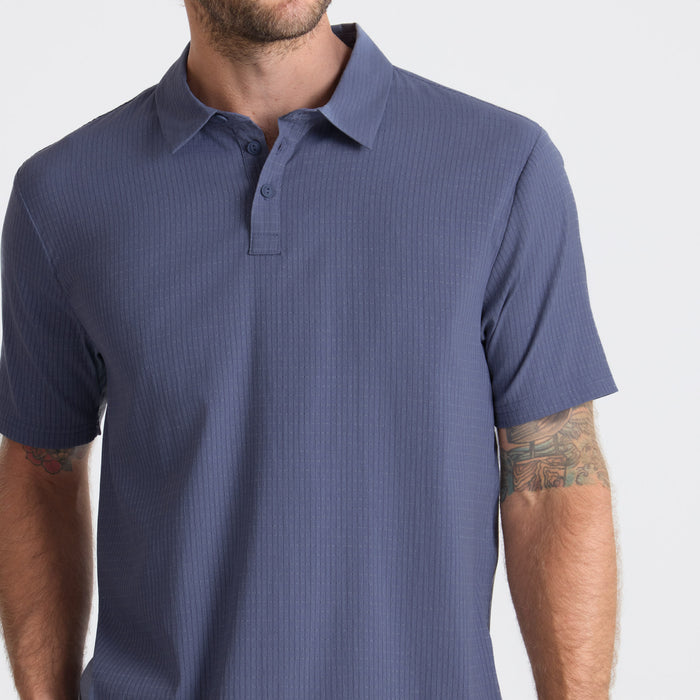 Close-up of a textured Roark active polo shirt highlighting its durable collar and sleeves, perfect for outdoor adventures.
