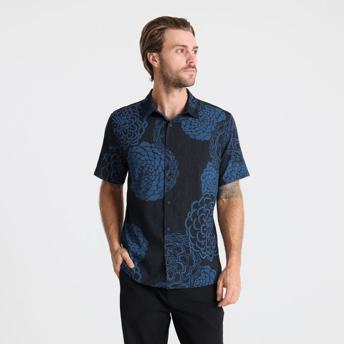 Close-up of a blue textured shirt featuring detailed collar and button design, embodying Roark’s adventure-ready apparel.