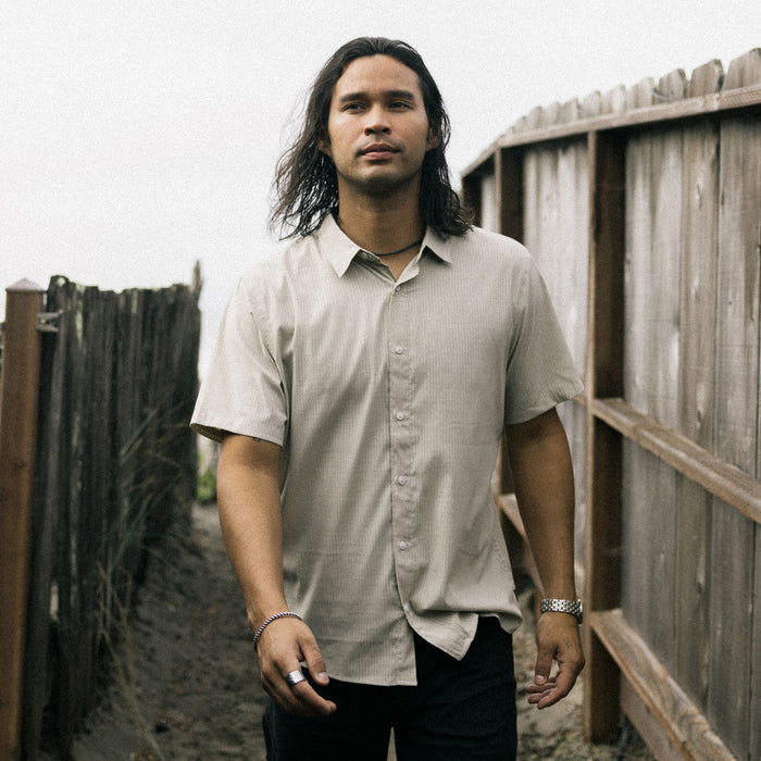 Man with black hair and facial hair wearing Roark's Bless Up Shirt featuring visible collar, shoulders, and sleeves, perfect for outdoor adventures.