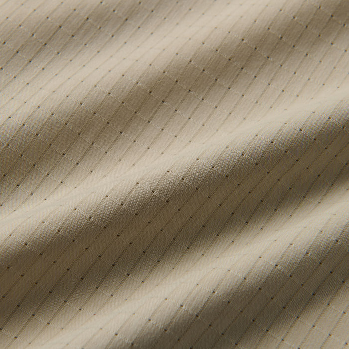 Close-up of beige fabric with detailed microperforation, capturing the essence of Roark's adventure-ready apparel.