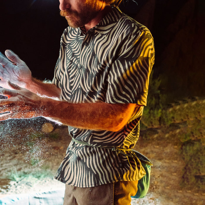 Adventurous man with a beard, moustache, and cap, wearing goggles looking ready for an outdoor adventure