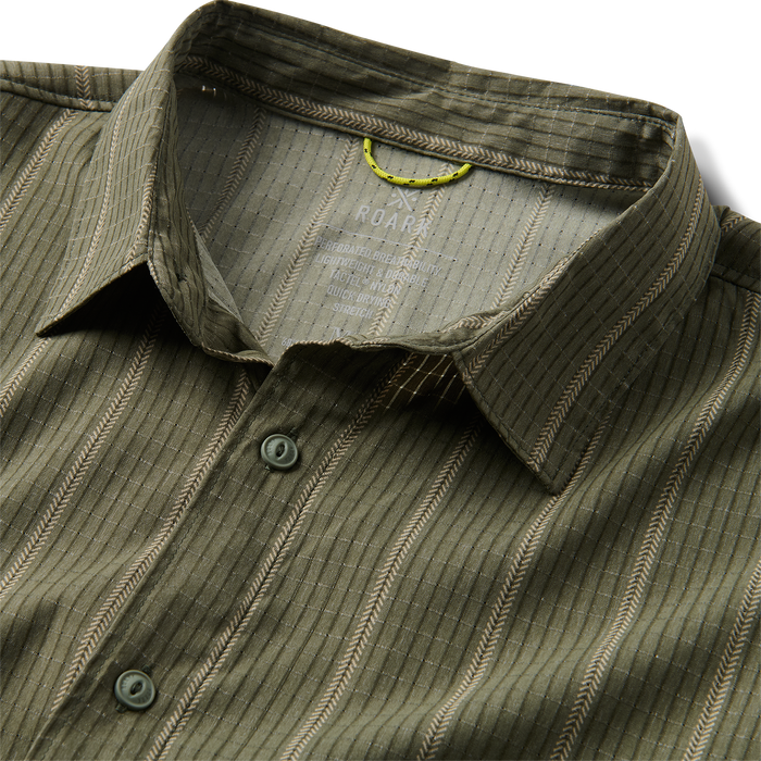 Close-up of a Roark dress shirt featuring detailed collar and buttons, crafted from high-quality textile, perfect for travel and outdoor adventures.