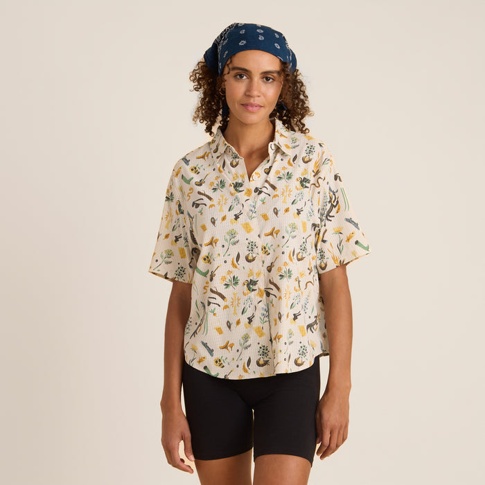 A man wearing a moon-patterned Roark Bless Up Button Up Shirt, standing with his hands in his pockets.
