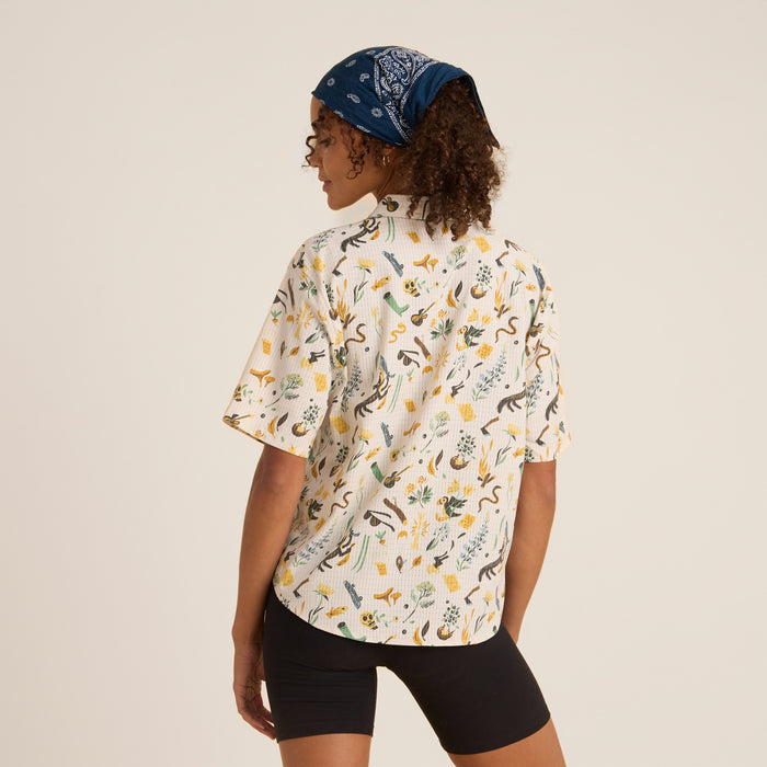 A man wearing a moon-patterned Roark Bless Up Button Up Shirt over a t-shirt, looking stylish and confident.