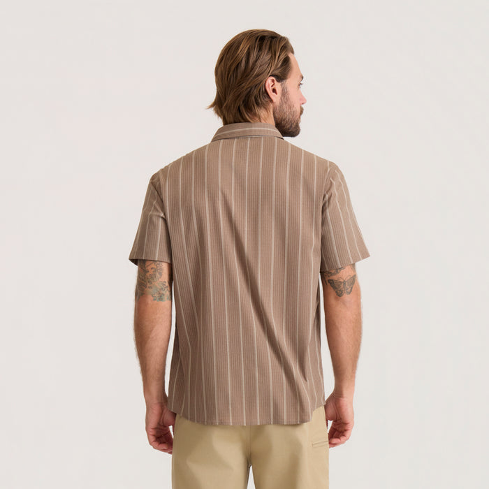 Men's short-sleeve button-up shirt in mushroom with vertical pinstripe, shown from back on model wearing khaki pants