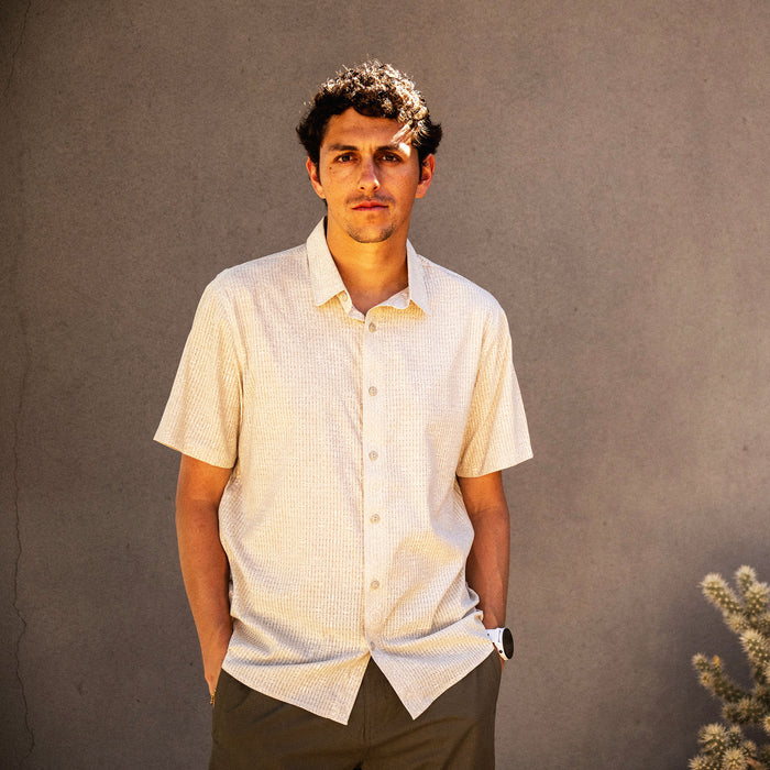 Bless Up Breathable Stretch Shirt in sand worn by model with hands in pockets, front view against neutral background