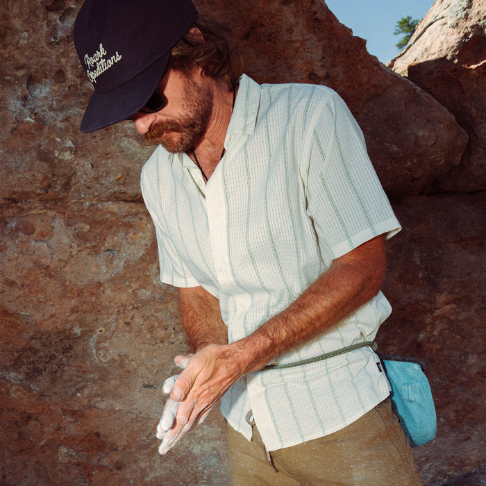 Outdoor enthusiast wearing a cap, showcasing versatile headgear and rugged clothing style in a natural setting, ideal for adventure and travel.