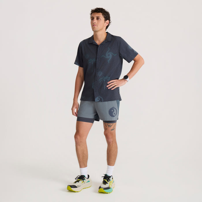 Bless Up Trail Button Up Shirt in ebony with teal geometric print, worn by man on model with matching shorts