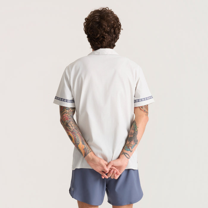 Close-up of a stylish active silver polo shirt featuring a detailed collar and sleeve design, ideal for adventure and travel.