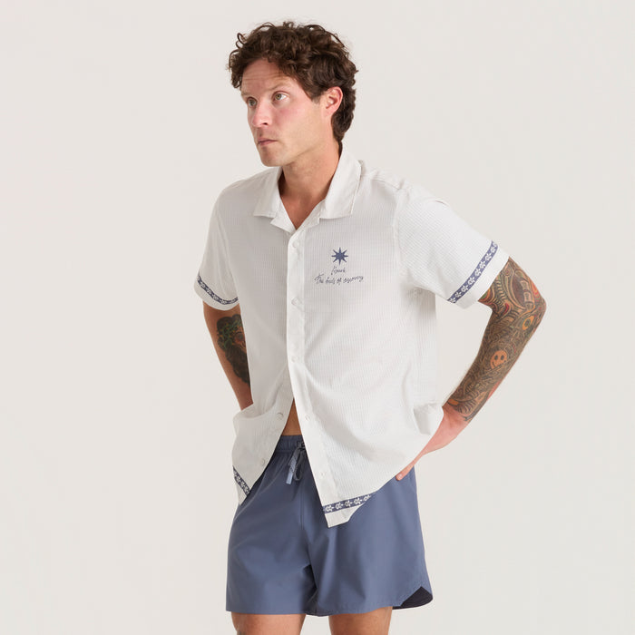 Active runner wearing a sleek silver Roark polo shirt and shorts on a dynamic run, embodying adventure and endurance.