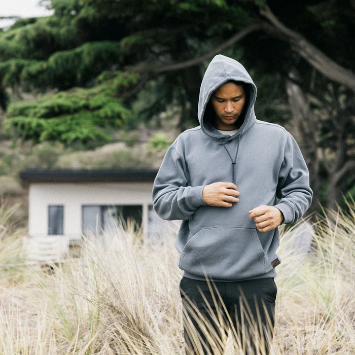 Grey denim hoodie with detailed stitching and adjustable hood, perfect for outdoor adventures and travel.
