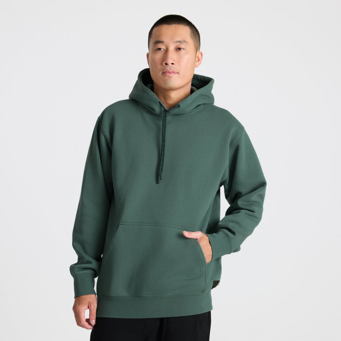 Active man wearing a hooded Roark shirt, perfect for adventure and travel, in a dynamic outdoor setting