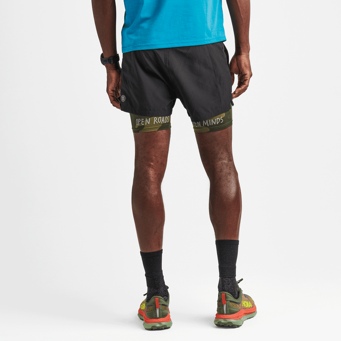 A man wearing the Roark Bommer 3.5" Shorts in Black, demonstrating their comfortable fit and versatile style for various activities.