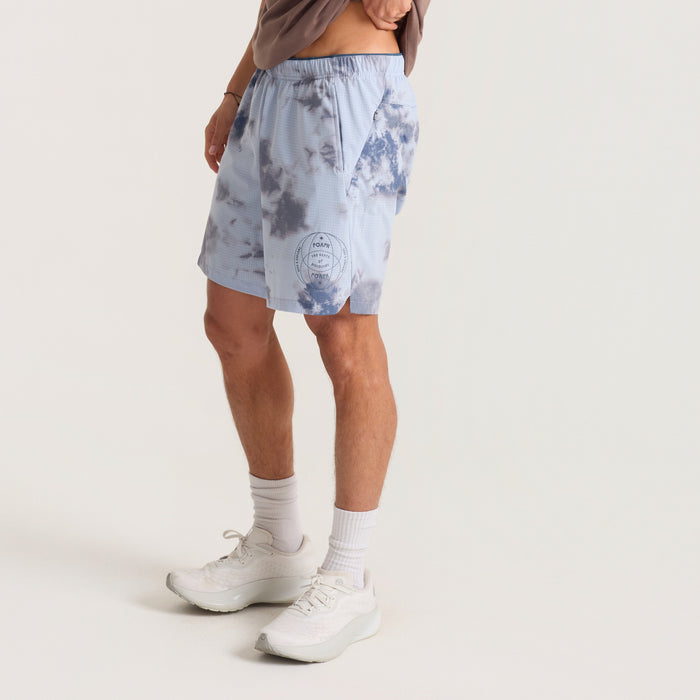Assorted styles of Roark adventure-ready shorts including boardshorts, active wear, and Bermuda trunks, arranged outdoors emphasizing versatility and durability for travel and adventure.