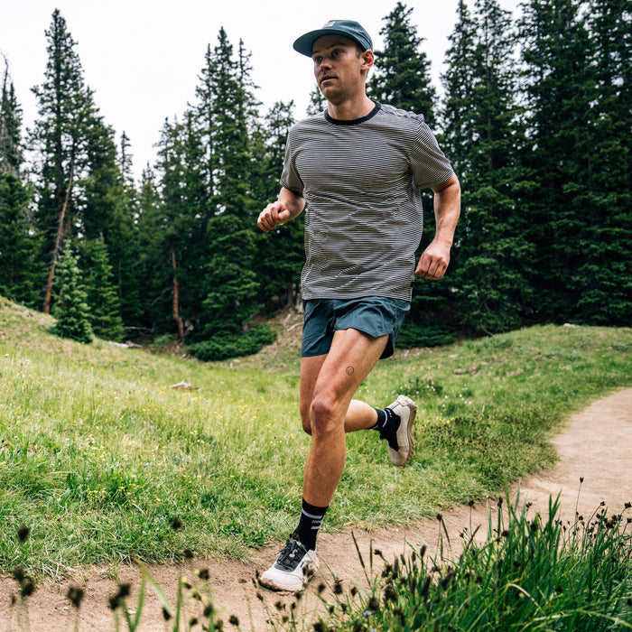 Man engaged in outdoor recreation wearing sturdy shorts and shoes, showcasing active lifestyle in a natural setting