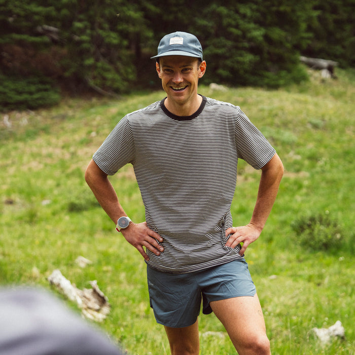 Adventurous person in summer outfit with shorts and headgear enjoying recreational outdoor activities