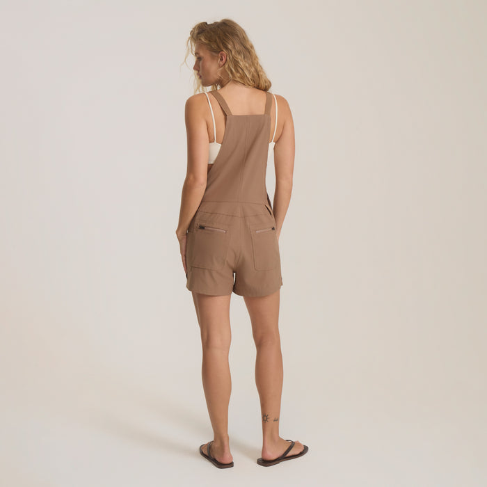 Canyon Romper in mocha tan worn by model from back, showing square neckline, adjustable straps, and cargo pockets