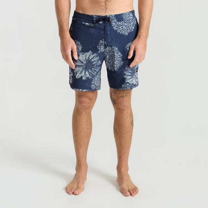 Versatile Roark navy boardshorts perfect for travel and outdoor activities, displayed in a natural setting.