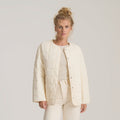 Cloud Liner Jacket in bone worn by model over matching cream knit and trousers, quilted button-front design