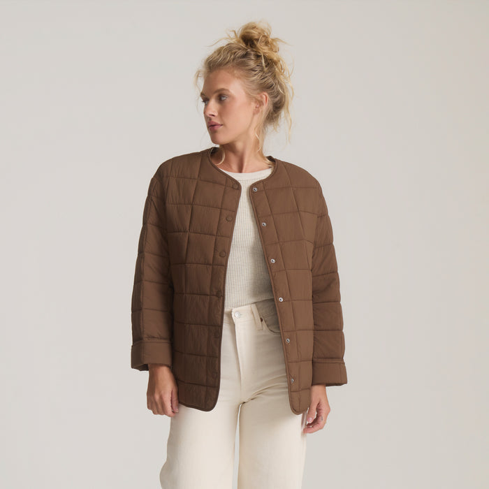 Cloud Liner Jacket in coco bean brown with quilted pattern, worn over cream sweater and off-white pants on model