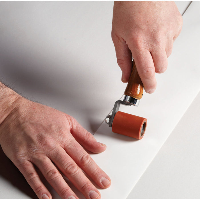 Seam Roller Pressing White RV Roof Repair Tape onto Surface - Installation Detail | United RV Parts