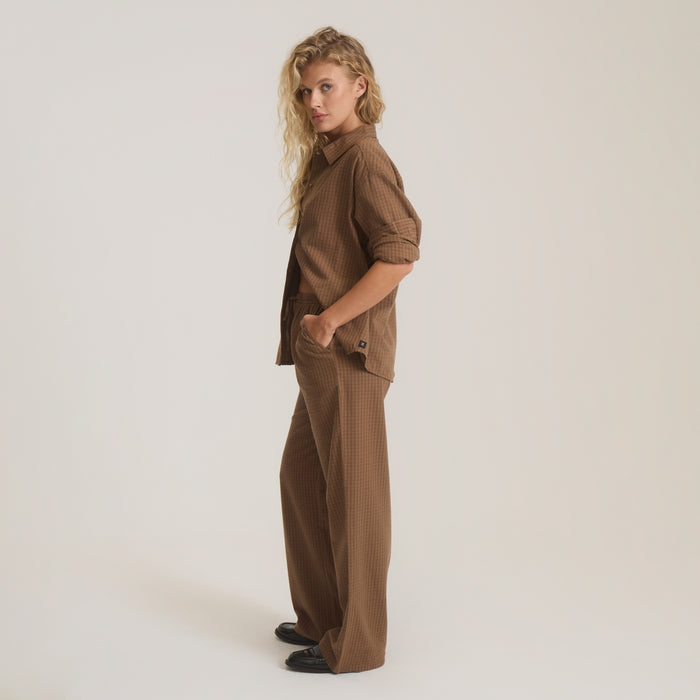 Woman wearing brown textured Costa button-up shirt with matching wide-leg trousers, standing against neutral background