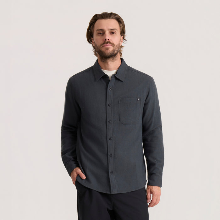 Charcoal gray organic cotton flannel shirt worn by model, featuring long sleeves, button front closure, and chest pocket detail