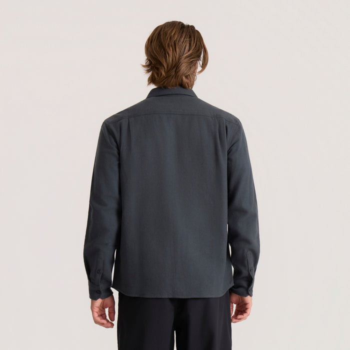 Dark charcoal organic cotton flannel shirt on model shown from back, long sleeves with button cuffs