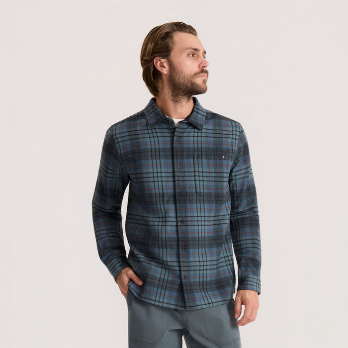 Crossroads organic cotton flannel in dark slate plaid worn by man in profile view, featuring long sleeves and button front
