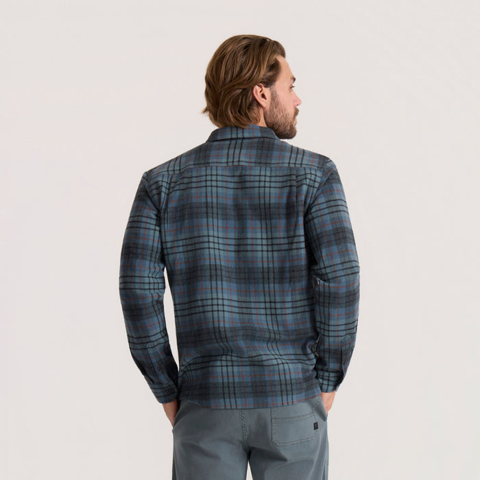 Men's dark slate blue plaid flannel shirt with long sleeves worn on model shown from behind against neutral background